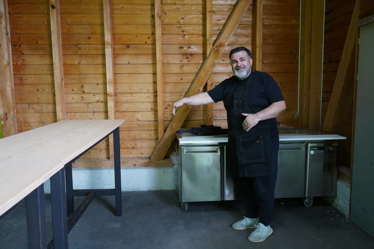 Pächter Athanasios Dailianis steht vor der Holzwand.